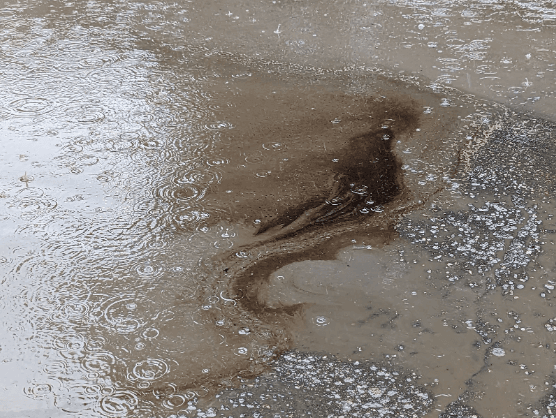 Brown murky water exiting a concrete facility